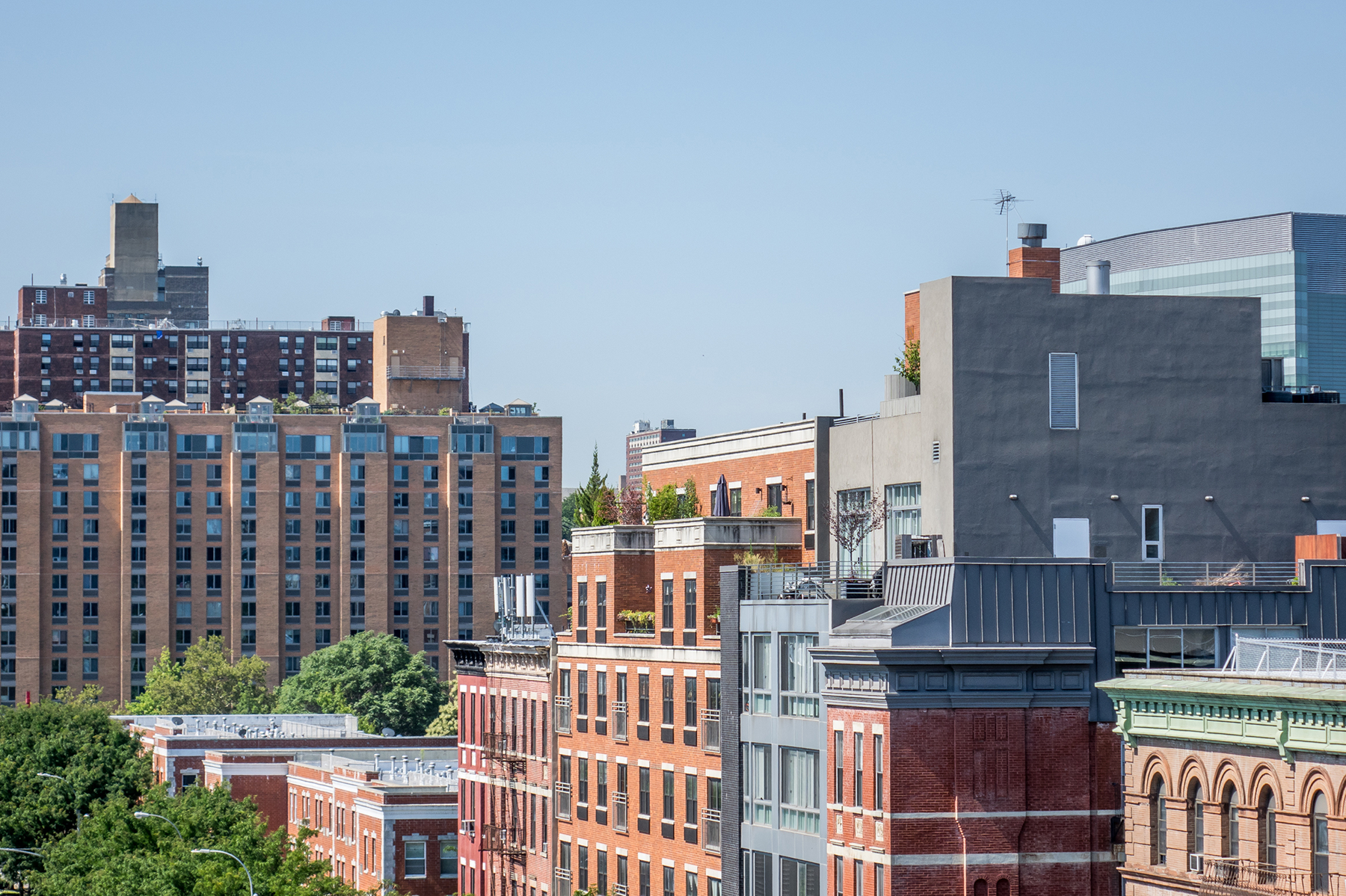 A photo of several brown, urban residential buildings in New York City.